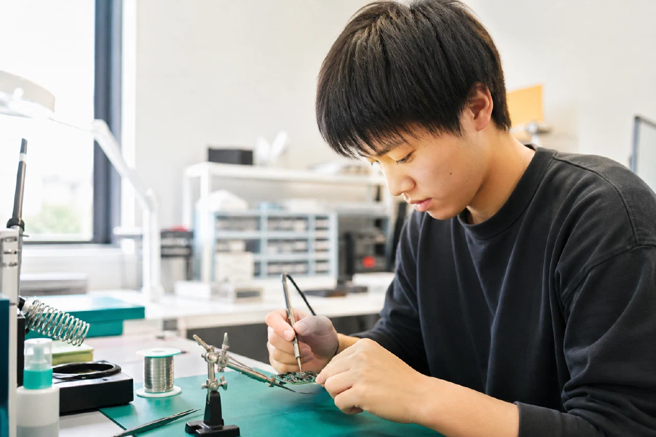 明るい作業台で電子基板を組み立てる人物のコンセプト写真